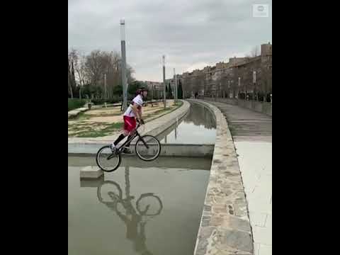 Cyclist hops across fountain on bike